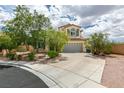 Landscaped front yard of home with mature trees, bushes and stone walkway leading to a two car garage at 11769 Via Vera Cruz Ct, Las Vegas, NV 89138