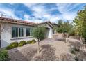 Beautifully landscaped front yard with mature trees and a charming brick walkway at 11843 Cogoleto Ave, Las Vegas, NV 89138