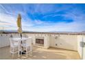 Outdoor patio with an incredible view, a fireplace, and contemporary white furniture at 1329 Jewelstone Cir, Henderson, NV 89012