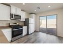 Bright kitchen with white cabinets, stainless steel appliances, and sliding glass doors opening to the backyard at 1713 Desert Path Ave, North Las Vegas, NV 89032