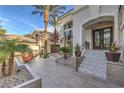 Inviting front entrance featuring tiled steps, potted plants, and outdoor seating surrounded by lush landscaping at 1912 Glenview Dr, Las Vegas, NV 89134
