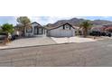 Attractive house with a 2-car garage, desert landscaping, and mountain backdrop at 2222 Little River Ct, Las Vegas, NV 89156
