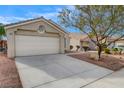 Inviting single-story home featuring a two-car garage, desert landscaping, and a well-maintained yard at 3417 Steppe St, North Las Vegas, NV 89032