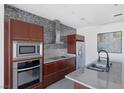 Close up of modern kitchen featuring sleek cabinetry and backsplash at 4471 Dean Martin Dr # 1202, Las Vegas, NV 89103