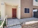 Close-up of a home's front entrance featuring a modern door, stone walkway, and landscaped garden bed at 4472 Sapphire Moon Ave, North Las Vegas, NV 89084