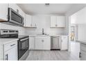 Updated kitchen with stainless steel appliances and white cabinets and countertops at 4980 Becky Pl, Las Vegas, NV 89120