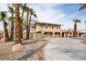 Exterior home view features arched windows, terra cotta colored roof tiles, mature landscaping, and a paved driveway at 6130 Tara Ave, Las Vegas, NV 89146