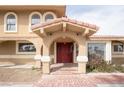 An inviting front door with arched portico, brick steps, and traditional design elements gives the entrance character at 6130 Tara Ave, Las Vegas, NV 89146