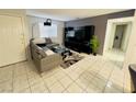 A bright living room with tile flooring, a grey sofa and large television at 6750 Del Rey Ave # 133, Las Vegas, NV 89146