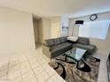 Living room with a gray leather sofa, a glass coffee table, and neutral walls at 6750 Del Rey Ave # 133, Las Vegas, NV 89146