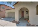 Exterior view of the front door with an arched entryway, desert landscaping, and a two-car garage at 7113 Forest Heights Ct, Las Vegas, NV 89166