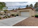 Exterior view of home highlighting the driveway and desert landscaping at 8657 Prairie Hill Dr, Las Vegas, NV 89134