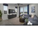 Relaxing living room with blue sofa and curtains, stylish decor, and view from multiple windows at 883 Apatite Pl # Lot 57, Henderson, NV 89011