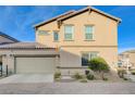 Side exterior view of a stucco two-story home with an attached two-car garage and a paver driveway at 1045 Spotted Saddle St, Henderson, NV 89015