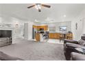 Open-concept living room with a kitchen featuring modern stainless steel appliances and a breakfast bar at 1077 Las Palmas Entrada Ave, Henderson, NV 89012