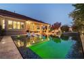 Luxurious outdoor pool area with lounge chairs, lush landscaping, and covered patio for relaxing and entertaining at 10813 Oak Shadow Ave, Las Vegas, NV 89144