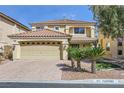 Inviting two-story home with a terra cotta tile roof, desert landscaping, and a two-car garage at 10900 Calcedonian St, Las Vegas, NV 89141
