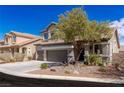 Charming two-story home with desert landscaping and a mature shade tree in the front yard at 11484 Roncat Ct, Las Vegas, NV 89141