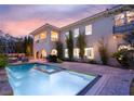 Backyard oasis with a sparkling pool, spa, covered patio, and lush landscaping at 1212 Muscato Ct, Las Vegas, NV 89144