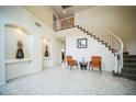 Grand foyer featuring tile floors, arched alcoves, and a curved staircase with white banisters and 2 chairs at 1304 Husson Ct, Las Vegas, NV 89142