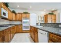 Spacious kitchen with granite countertops, tile floors, and wooden cabinetry featuring modern appliances at 1304 Husson Ct, Las Vegas, NV 89142