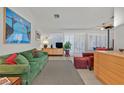 Inviting living room featuring a plush green sofa, modern art, and bright natural light from shuttered windows at 2608 Saltbush Dr, Las Vegas, NV 89134