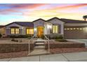 Inviting single-story home featuring landscaped front yard and a two-car garage at dusk at 3042 Lake Barkley Rd, Henderson, NV 89052