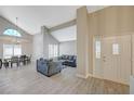 Bright living room with wood floors, cathedral ceilings, and dining area at 371 Sanctuary Ct, Henderson, NV 89014