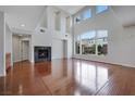 Open living room with a fireplace, hardwood floors, and large windows at 3728 White Lion Ln, North Las Vegas, NV 89084