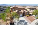 A two-story home with desert landscaping, two car garage and a large driveway set against a beautiful mountain backdrop at 537 Blanche Ct, Henderson, NV 89052