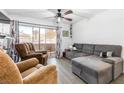 Bright living room boasts wood-look tile floors, ceiling fan, and sliding glass doors to a patio at 5710 E Tropicana Ave # 1166, Las Vegas, NV 89122