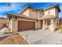 Charming two-story home featuring a two-car garage and a welcoming covered porch with stylish architectural details at 5861 Lakeland Village Dr, North Las Vegas, NV 89081