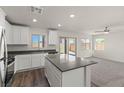 Modern kitchen with stainless steel appliances, a center island, and access to the yard at 6215 Blood Lily Ave, Las Vegas, NV 89122