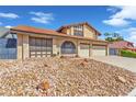 Two-story home featuring a tile roof, rock landscaping, and a two-car garage, enhancing curb appeal at 6320 Peppermill Dr, Las Vegas, NV 89146