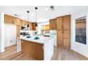 Bright kitchen features a waterfall island with wood accents and stainless steel appliances at 7832 Desert Candle Way, Las Vegas, NV 89128