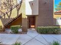Building entrance featuring a brown door, gray walkway and green landscaping at 9000 Las Vegas Blvd # 1097, Las Vegas, NV 89123