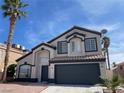 Charming two-story home featuring desert landscaping, a black garage door, and palm tree at 9139 Scallop Reef Ave, Las Vegas, NV 89147