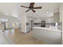 Open-concept kitchen featuring gray cabinets, stainless steel appliances, mosaic backsplash, and a center island at 9139 Scallop Reef Ave, Las Vegas, NV 89147