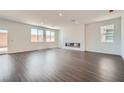 Spacious living room with wood floors, bright white walls, large windows and a modern fireplace at 9825 Lost Horse Ave, Las Vegas, NV 89178