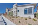 A modern home with desert landscaping, and sidewalk at 990 Golden Summit Dr, Las Vegas, NV 89138