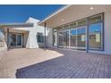 Paver patio with sliding glass doors and neutral colored exterior at 990 Golden Summit Dr, Las Vegas, NV 89138