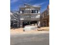 Two-story home under construction with modern design, scaffolding, and a two car garage at 10004 River Corral St, Las Vegas, NV 89166