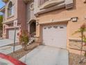The townhome has an attached two-car garage with convenient access and desert landscaping at 10051 Sand Key St, Las Vegas, NV 89178