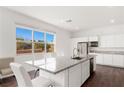Bright kitchen features a large island with granite countertops, stainless steel appliances, and white cabinetry at 10879 Artesano Ave, Las Vegas, NV 89135
