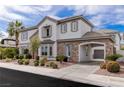 An angled view of a lovely two-story home with a port cochere and mature landscaping at 2001 Alcova Ridge Dr, Las Vegas, NV 89135