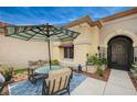 Comfortable front patio with a sitting area and shade umbrella at 2015 Sun Cliffs St, Las Vegas, NV 89134