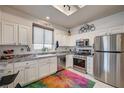 Bright kitchen with white cabinets, stainless steel appliances, and a colorful rug at 2015 Sun Cliffs St, Las Vegas, NV 89134