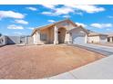 Well-maintained front exterior showing desert landscaping, wide driveway and a two-car garage at 2419 Country Orchard St, North Las Vegas, NV 89030