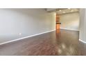 Spacious living room with dark hardwood floors, neutral walls, and kitchen access at 53 Blue Beak Way, Henderson, NV 89012