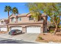 Attractive townhome with tile roof, dual garage, desert landscaping, and a car in the driveway at 5382 Runningbrook Rd, Las Vegas, NV 89120